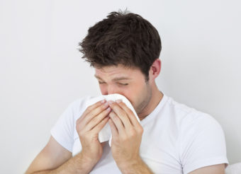 Man Sneezing Into A Tissue